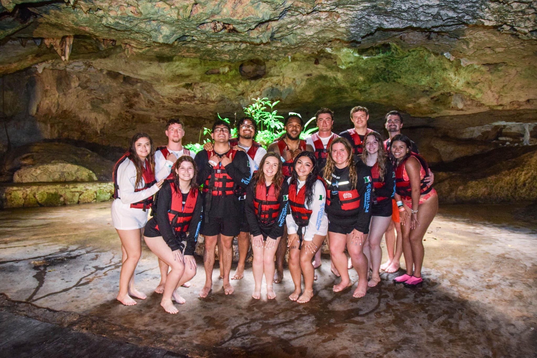 Team in cave adventure with life jackets