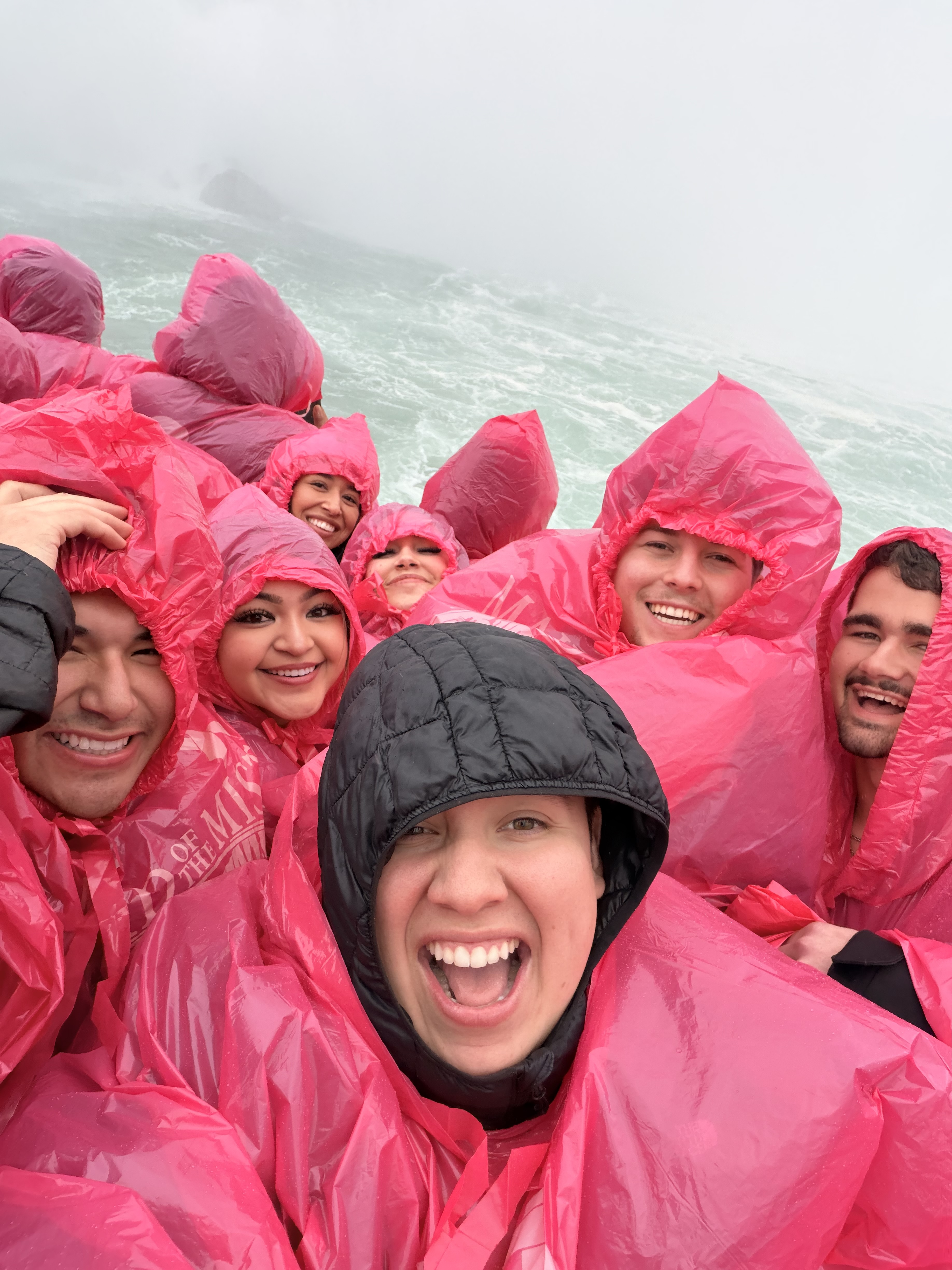 Team in pink rain ponchos at the coast
